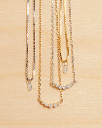 The Bella Diamond Charm Necklace is the first necklace on the left and the third necklace View 7
