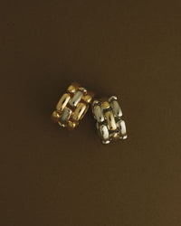 The Luv Aj Noir Link Ring in Silver and Gold in a flat lay photo on a brown background View 3