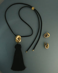 The Luv Aj Solstice Knot Tassle Ring in a flat lay photo  View 2