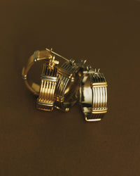 The Luv Aj Two Tone Sierra Bar Hoops in Gold on a brown background View 3